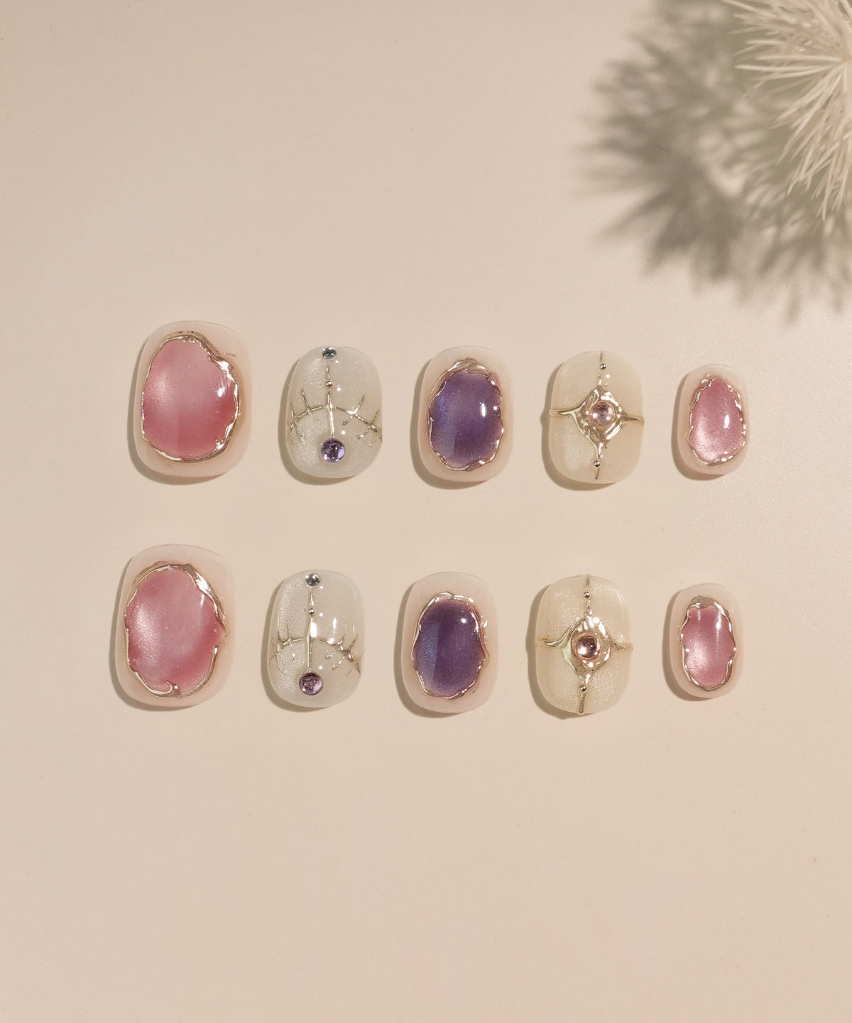ホワイトベースにピンクや紫の天然石風ストーンとシルバーのエスニック模様が施されたショートラウンドネイルチップ10枚セット。
