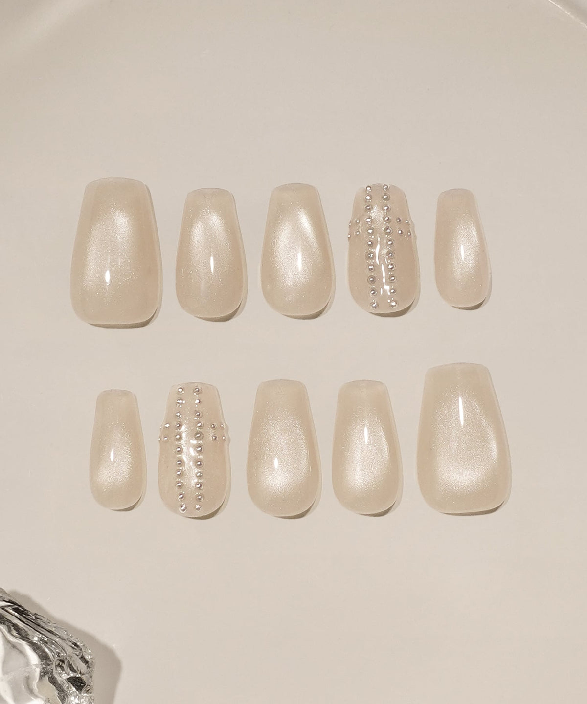 上品に輝くベージュのマグネットネイルに、繊細なスタッズでクロスモチーフを施したバレリーナシェイプのネイルチップ10本セット。
